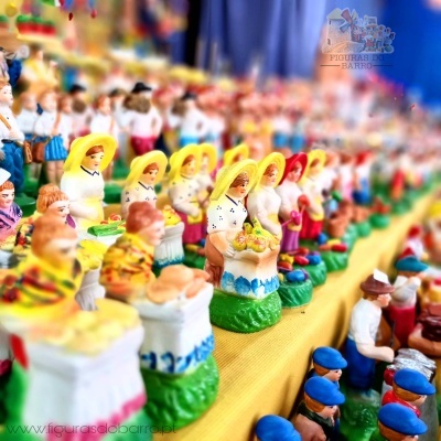 Figuras artesanais coloridas em uma mesa com toalha amarela