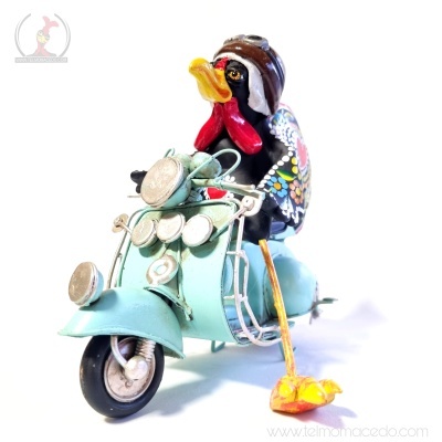 Estatueta metálica de galo em scooter verde