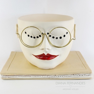 Vaso decorativo rosto feminino com óculos e base de livro