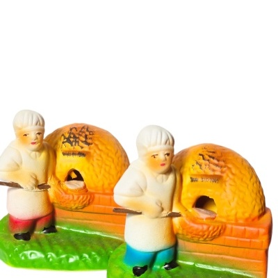 Figuras de resina de padeiros com forno de barro amarelo e base verde.