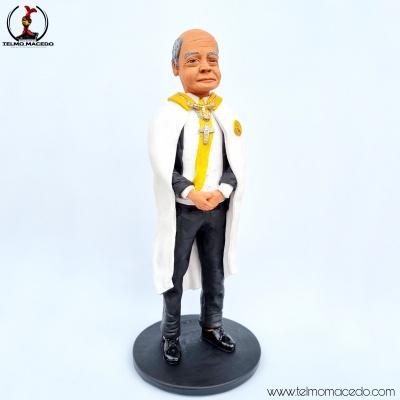 Estátua masculina idosa com capa branca e detalhes amarelos