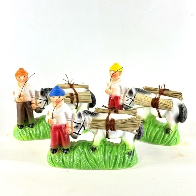 Estatuetas de pescadores com burros carregados, com cores vivas e base verde