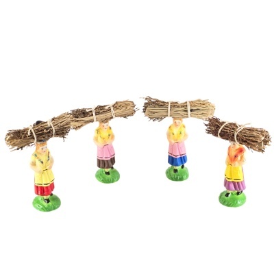 Três miniaturas de mulheres vestindo casacos coloridos e saias, com feixes de ramos na cabeça