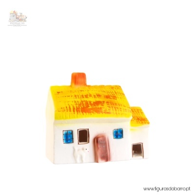 Miniatura de casa branca com telhado amarelo e detalhes em azul e castanho