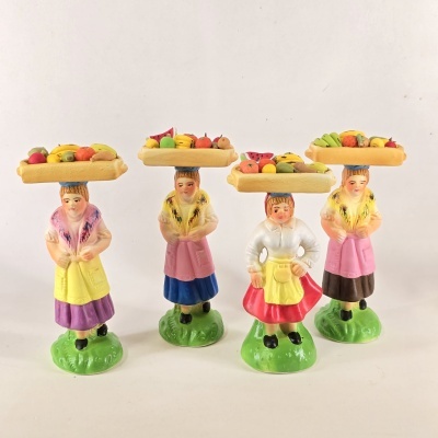 Figuras femininas decorativas em cerâmica com bandejas de frutas coloridas na cabeça