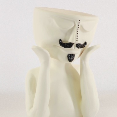 Vaso decorativo em cerâmica branca com rosto estilizado e detalhes pretos