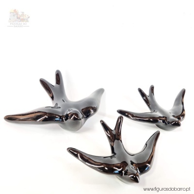 Três esculturas de pássaros em cerâmica preta brilhante em fundo branco