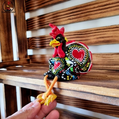 Figura decorativa de galo colorido em madeira pintada com padrões coloridos e corações