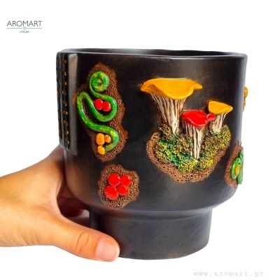 Vaso preto decorativo com relevos coloridos de cogumelos e plantas