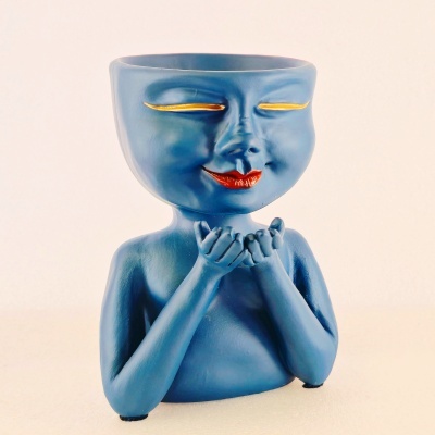 Vaso decorativo azul com rosto sorridente e mãos em concha