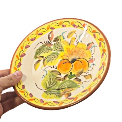 Prato de cerâmica pintado à mão com padrão floral colorido e borda decorada.