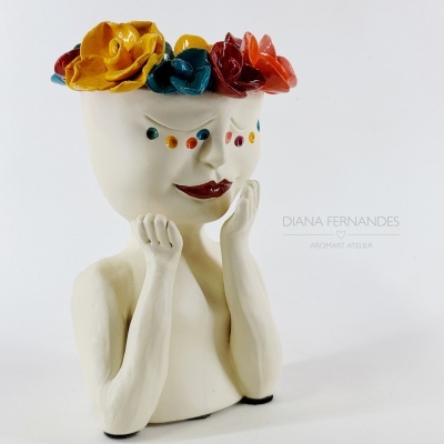 Vaso em cerâmica branco em forma de rosto com flores coloridas no topo