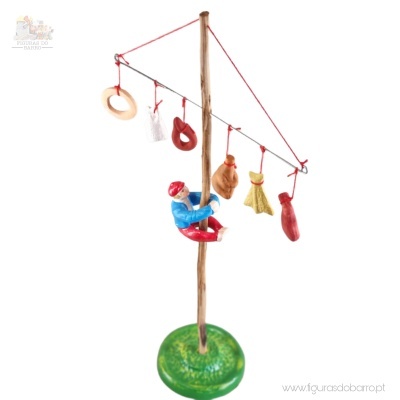 Figura decorativa com base verde, haste vertical de madeira e figuras penduradas em fio vermelho
