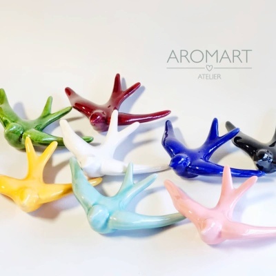 Oito pássaros decorativos cerâmicos coloridos com texto AROMART ATELIER ao fundo