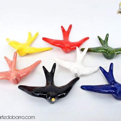 Sete andorinhas decorativas de cerâmica esmaltada em várias cores sobre fundo branco