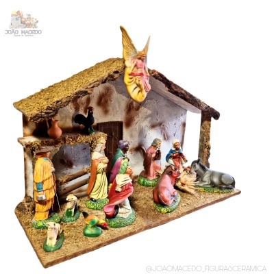 Presépio cerâmico colorido com figuras e casa rústica de telhado de palha