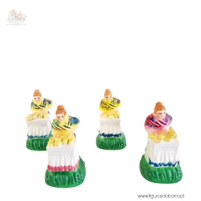 Quatro figuras decorativas de mulher sentada com xailes coloridos em troncos brancos