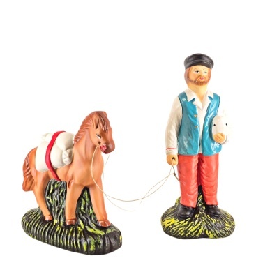 Figuras de cerâmica de um homem e um cavalo com corda, sobre bases verdes e pretas.