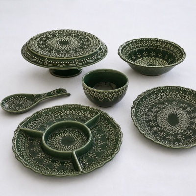 Conjunto de loiça verde em cerâmica com padrões brancos detalhados.