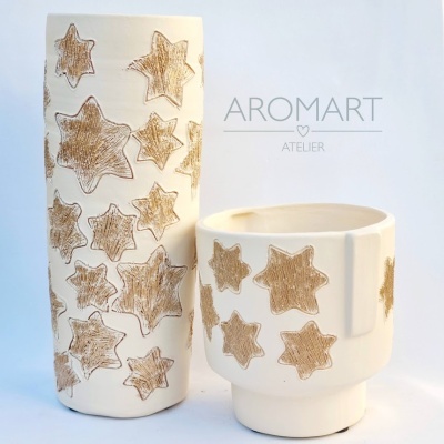 Vasos cerâmicos brancos com estrelas castanhas e texto Aromart Atelier