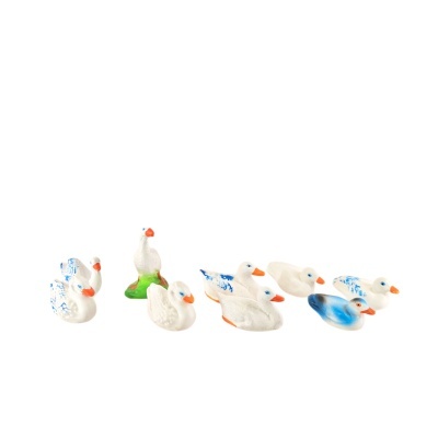 Oito patos de cerâmica brancos com detalhes azuis e bicos laranja sobre fundo branco