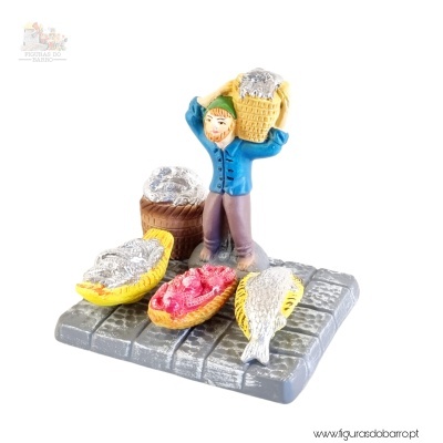 Miniatura de figura masculina com cesta de peixes em base pavimentada.