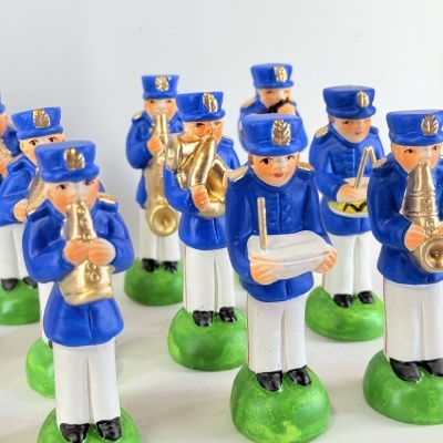 Figuras de músicos de banda em cerâmica com uniformes azuis e brancos segurando instrumentos