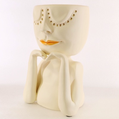 Vaso de cerâmica em forma de rosto com detalhes dourados e lábios laranja