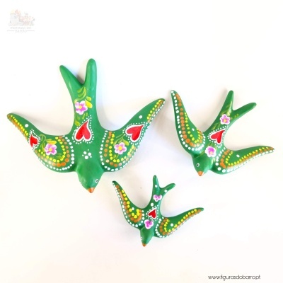 Figuras de pássaros verdes pintados com detalhes coloridos e padrões florais
