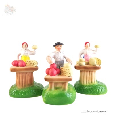 Figuras decorativas de vendedores com queijos sobre mesas e base verde