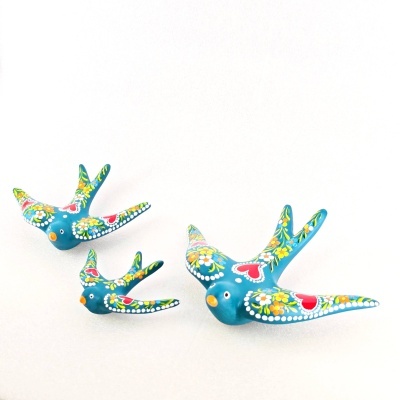 Três pássaros decorativos azuis pintados com flores e corações coloridos