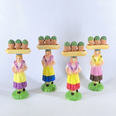 Estatuetas de mulheres com bandejas amarelas e vasos com cactos, em cores variadas