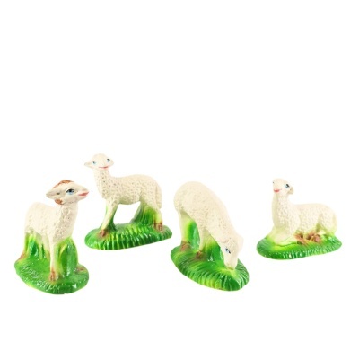 Quatro figuras tradicionais de ovelhas brancas com base verde
