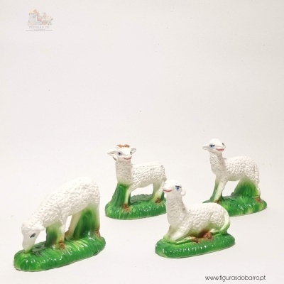 Figuras decorativas de alpacas ou lhamas brancas em bases verdes, em diferentes posições