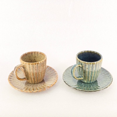 Duas chávenas com pires em cerâmica, castanha e verde, acabamento brilhante