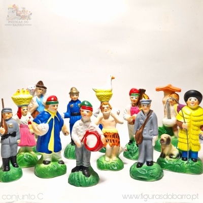 Figuras de barro pintadas à mão representando pessoas com roupas tradicionais e objetos em bases verdes.