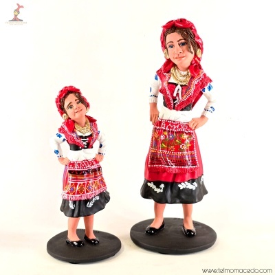 Miniaturas de mulheres com trajes tradicionais vermelhos e pretos em bases pretas