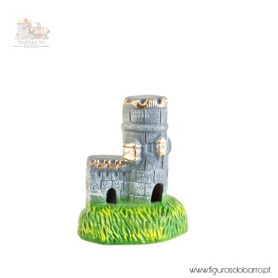 Miniatura de castelo cinzento com detalhes dourados sobre base verde