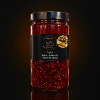 Frasco de molho picante vermelho com rótulo preto e selo de prémio bronze