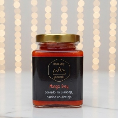 Frasco de vidro com molho vermelho e etiqueta preta com texto