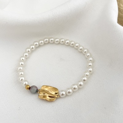 Pulseira de contas brancas que parecem pérolas com detalhe dourado e duas pequenas contas coloridas