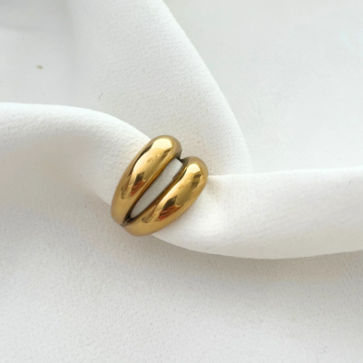 Anel dourado sobre tecido branco