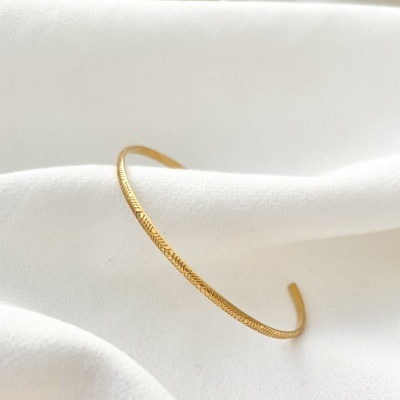 Bracelete dourado texturizado em tecido branco