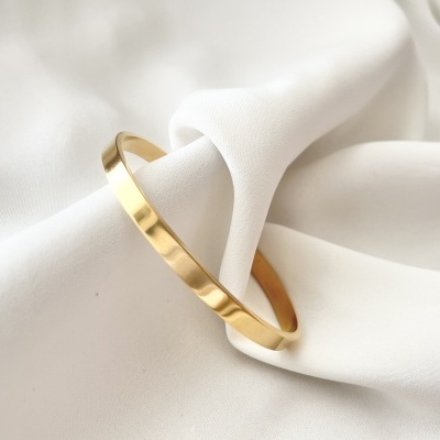 Anel dourado simples sobre tecido branco