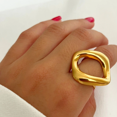 Anel dourado com design irregular usado na mão