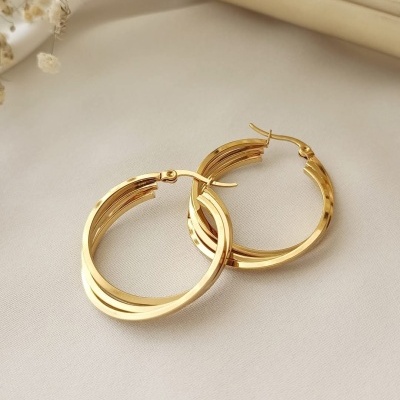 Brincos de argola dourados em tecido bege