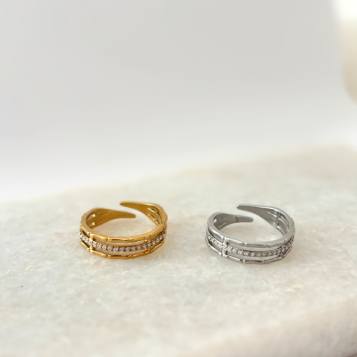 Dois anéis com cristais sobre superfície branca