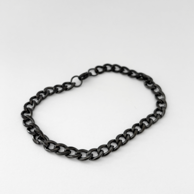 Corrente metálica preta com elos grossos sobre fundo branco