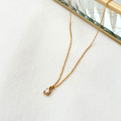 Colar dourado com pendente em forma de flor com pedra transparente