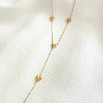 Colar dourado com corações sobre fundo branco